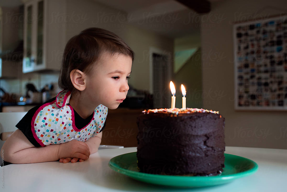 Girl Looks at 2 Candles on her Birthday Cake