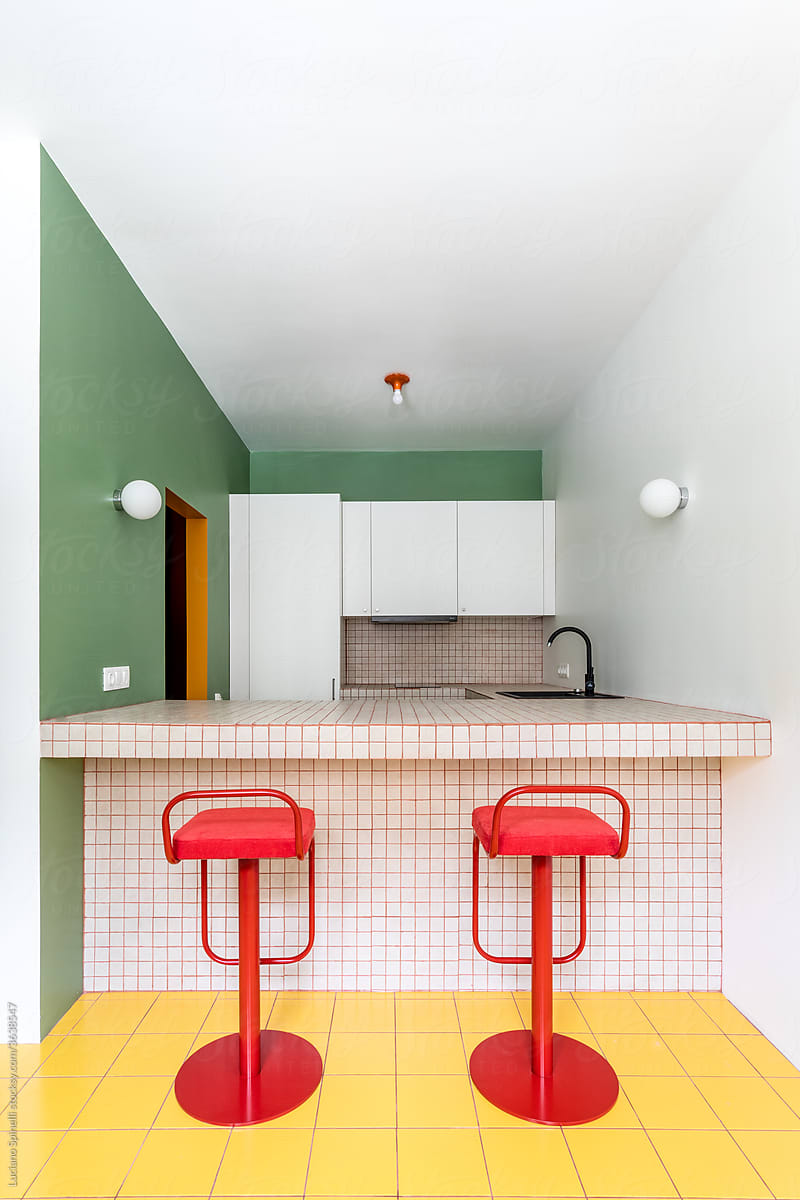 Two red empty stool in colourful stylish kitchen symmetric perspective