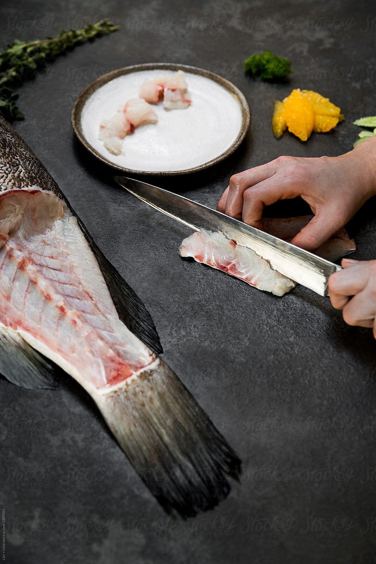 Chef Holding Knife Cutting Raw Fish For Plating by Stocksy Contributor  Lior + Lone - Stocksy