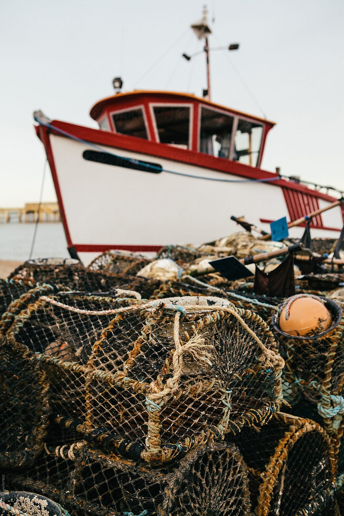 Fishing boat with lobster pots on an empty beach, Kent, UK.