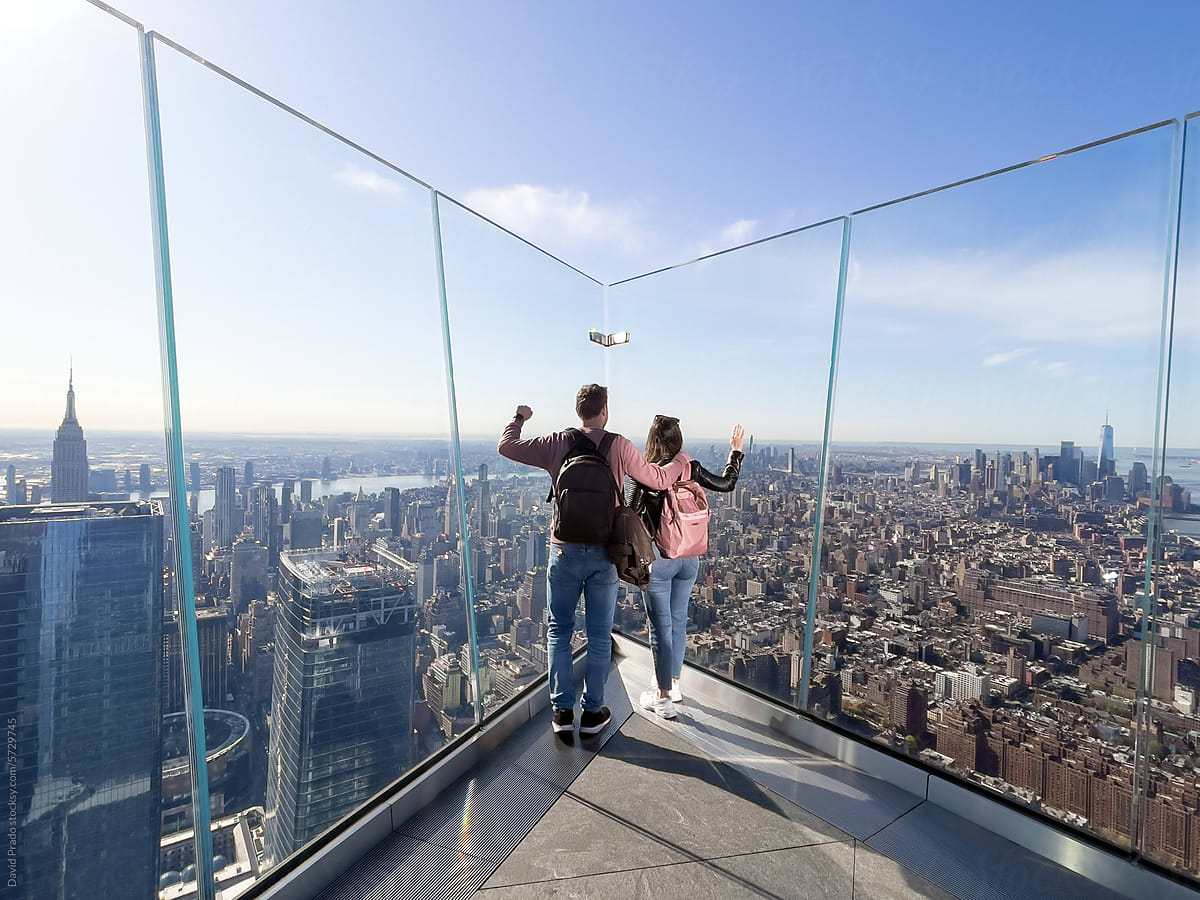 Man and Woman Overlooking Manhattan from Transparent Balcony
