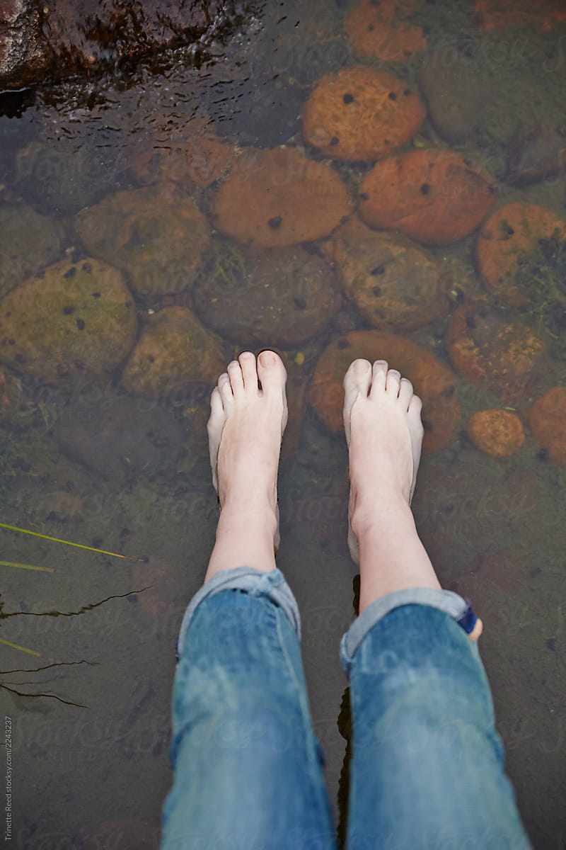 Woman relaxing in Japanese garden with her feet in the water