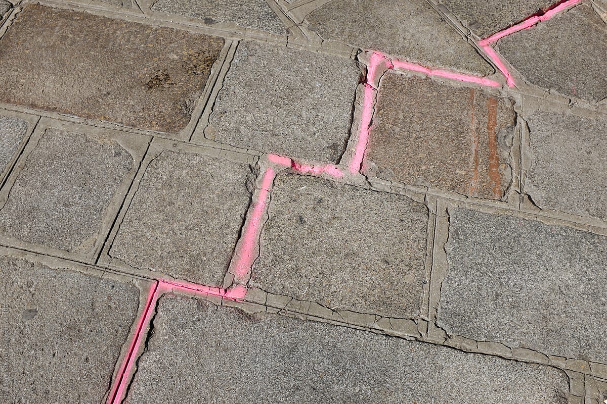 Pink spray painted line on sidewalk