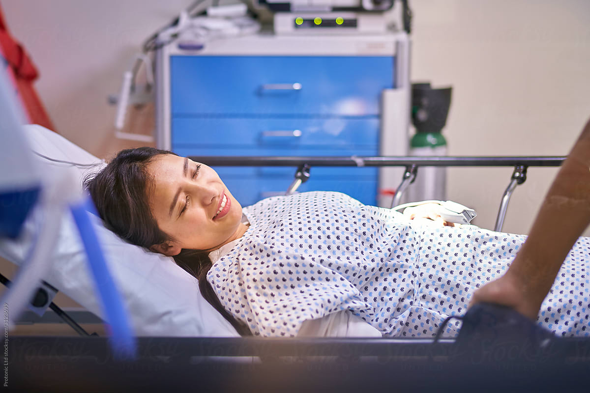 Young female patient with a smile in a hospital bed