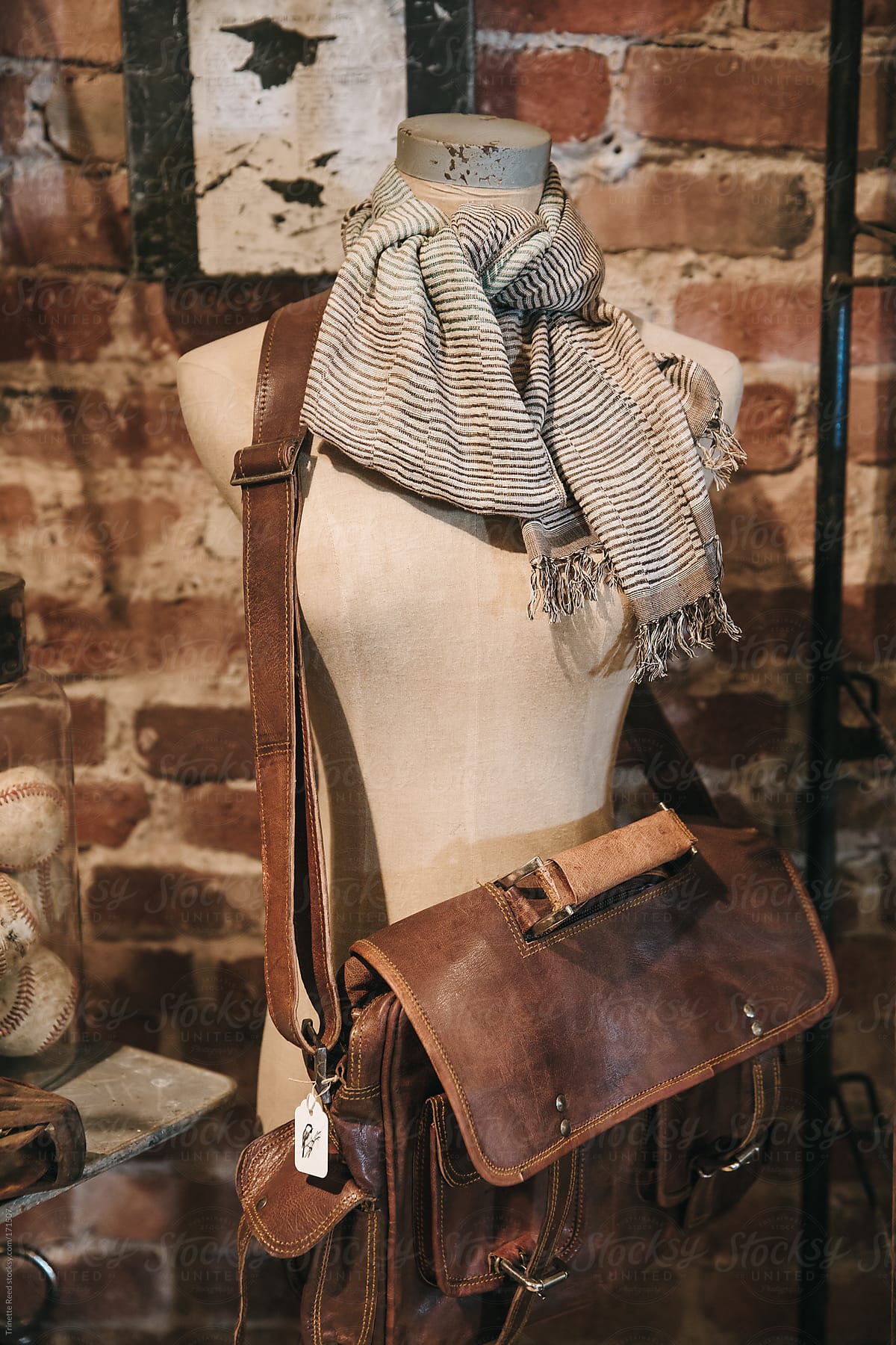Mannequin with leather bag inside small boutique store