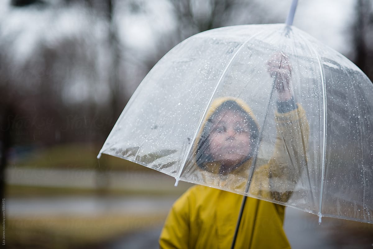 little boy closing an umbrella