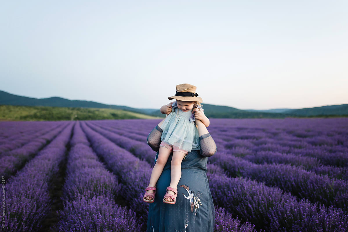 Mother playing with excited toddler in blooming lavender field