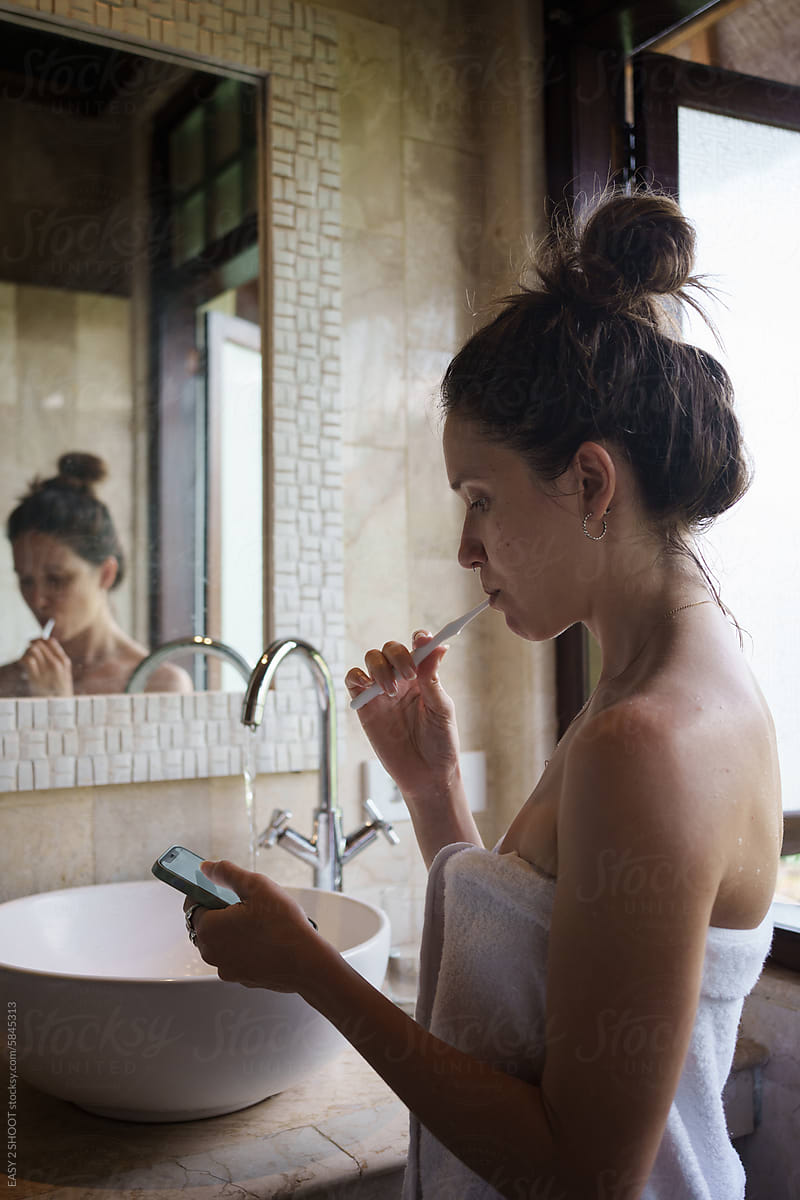Woman in Towel Checking Cell Phone