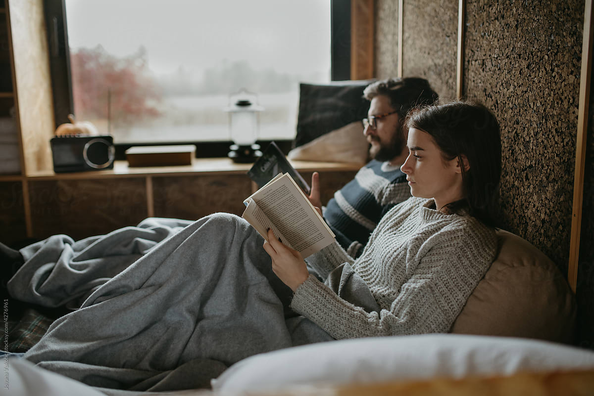 Couple sitting in a tiny house and reading book
