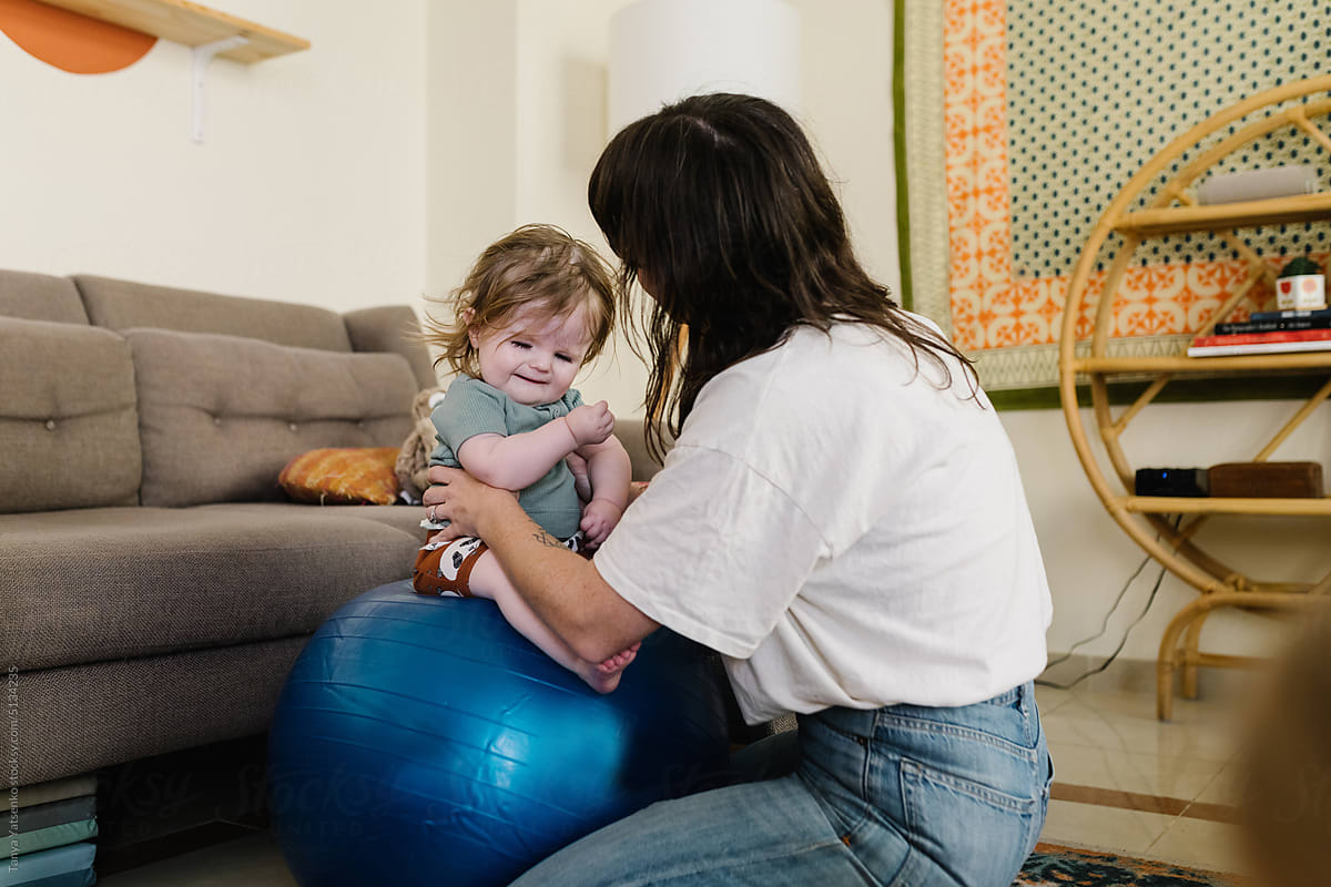 A little boy on a fitness ball with his mother