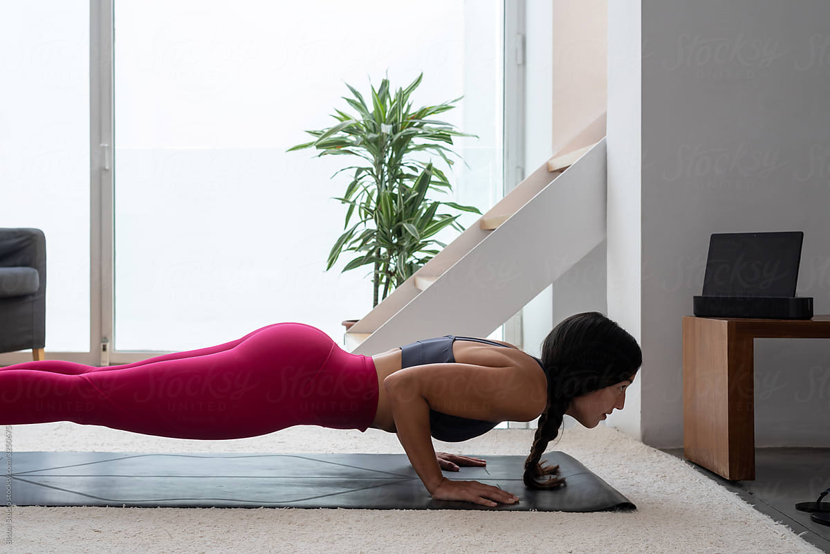 Fit woman following an online yoga session from home