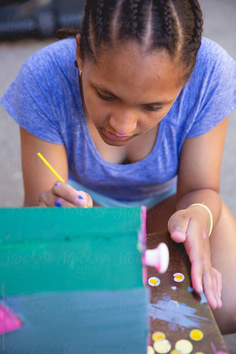 Teenage girl painting a homemade mailbox