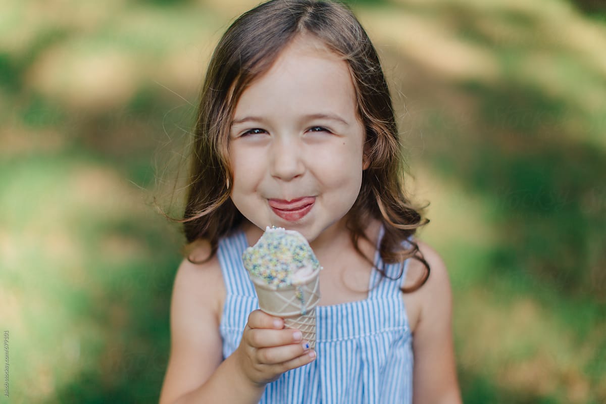 Cute And Happy Young Girl Eating Ice Cream Outside By Jakob Lagerstedt 