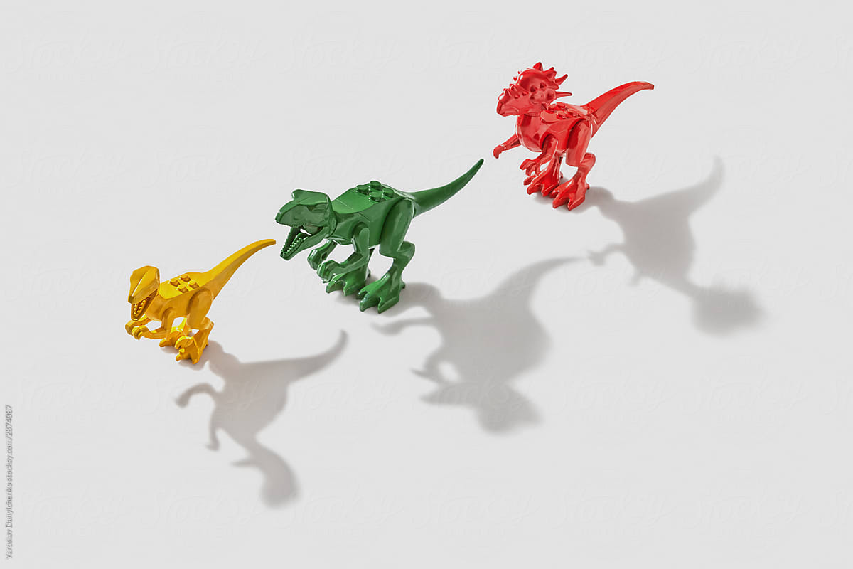 Three colored dinosaurs with shadows.