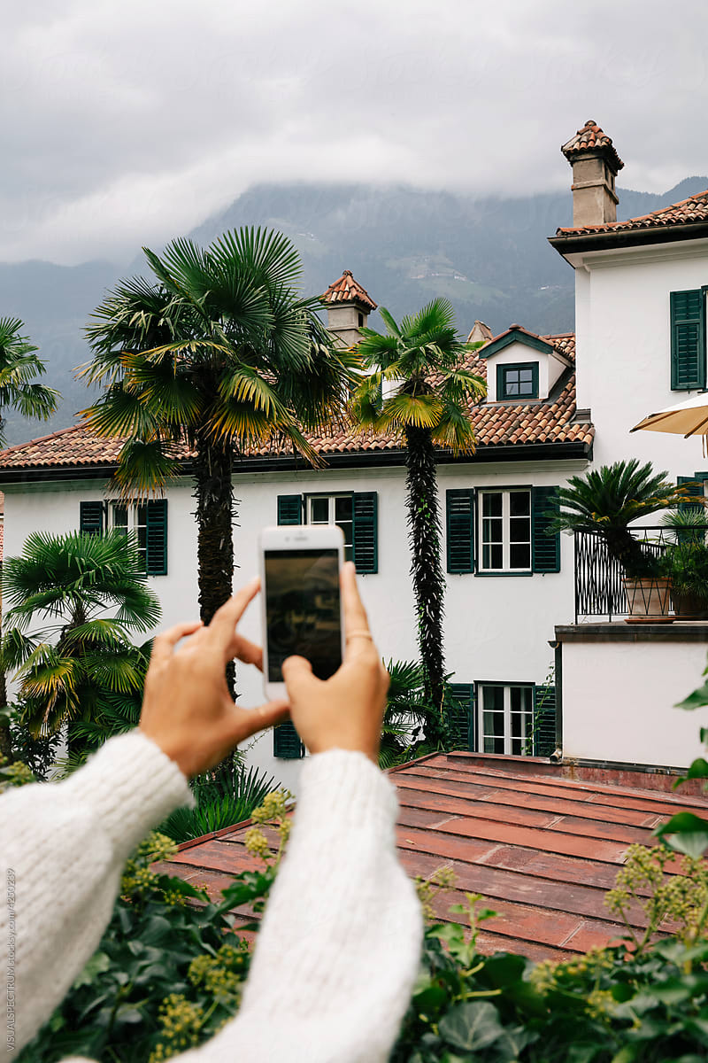 Woman Taking Photo of Large Pretty Villa
