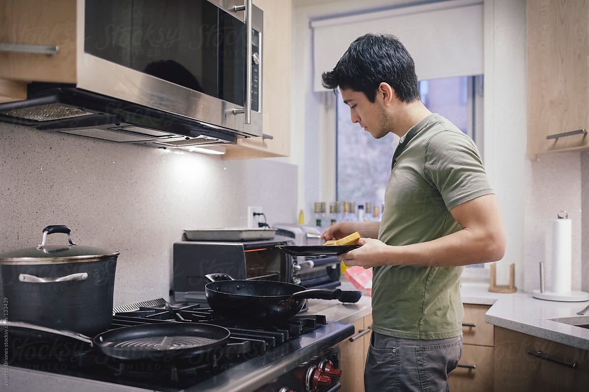 Young Hispanic - Latino Male Student Using Toaster Oven in Kitchen of New York Apartment