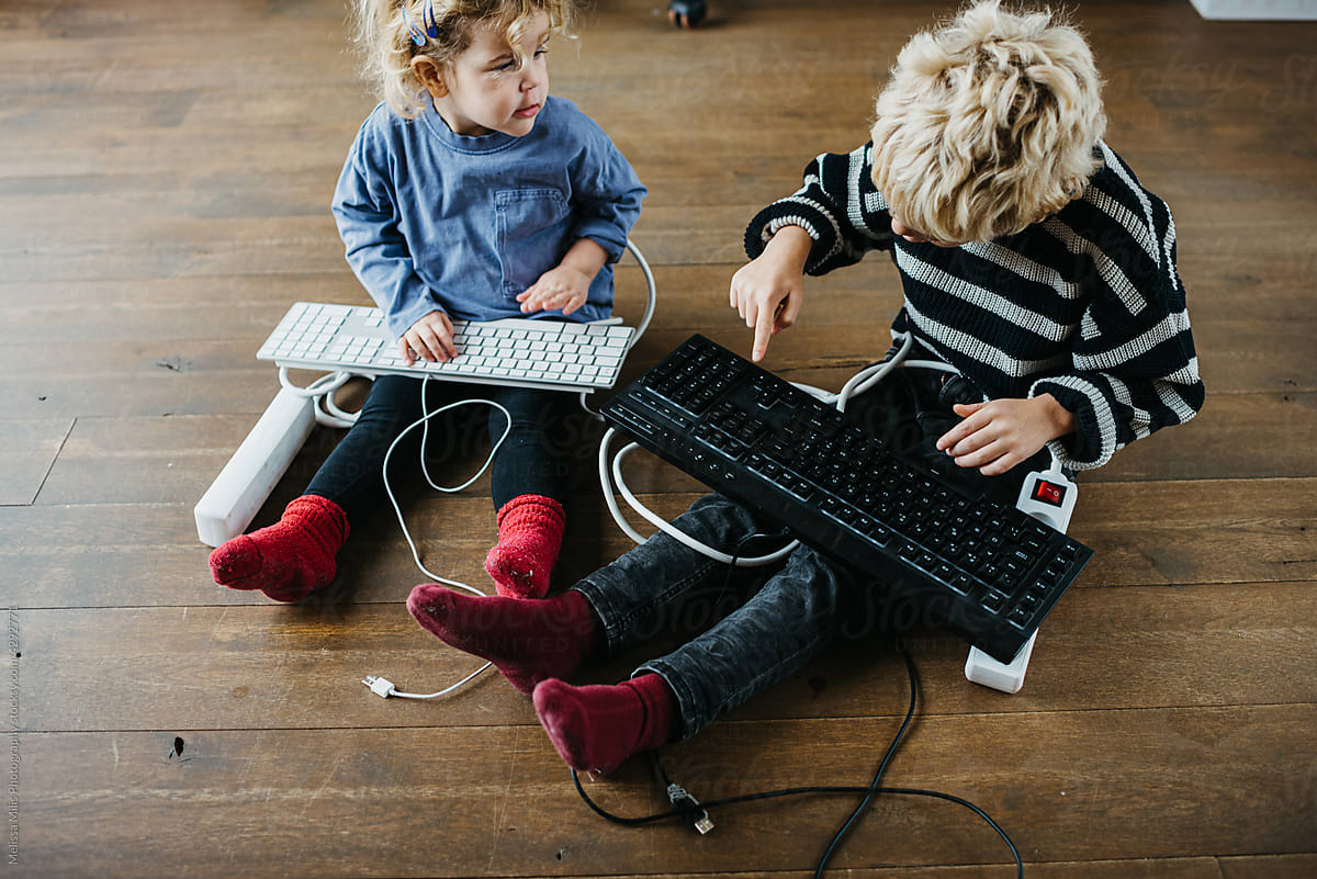 Cute kids playing with electronic devices at home