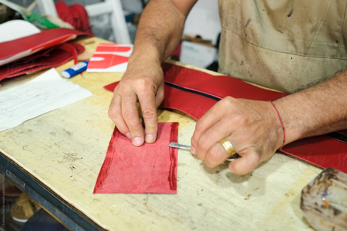 Craftsman applying glue to a piece of leather.