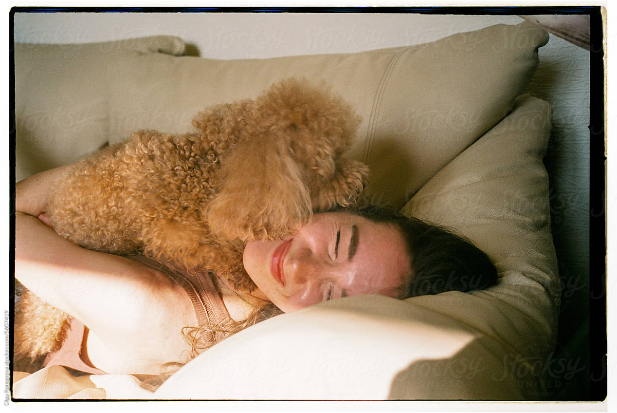 Portrait of young woman hugging her dog in the sunshine