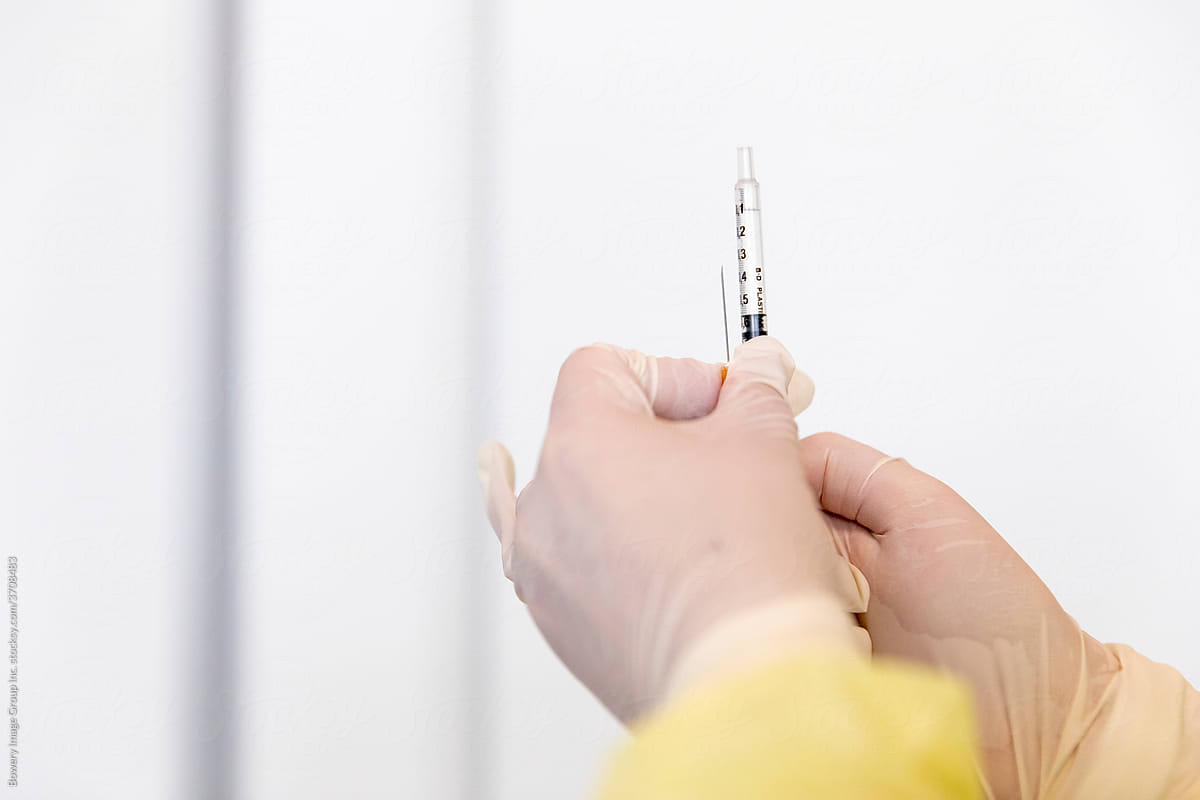 A syringe being held up