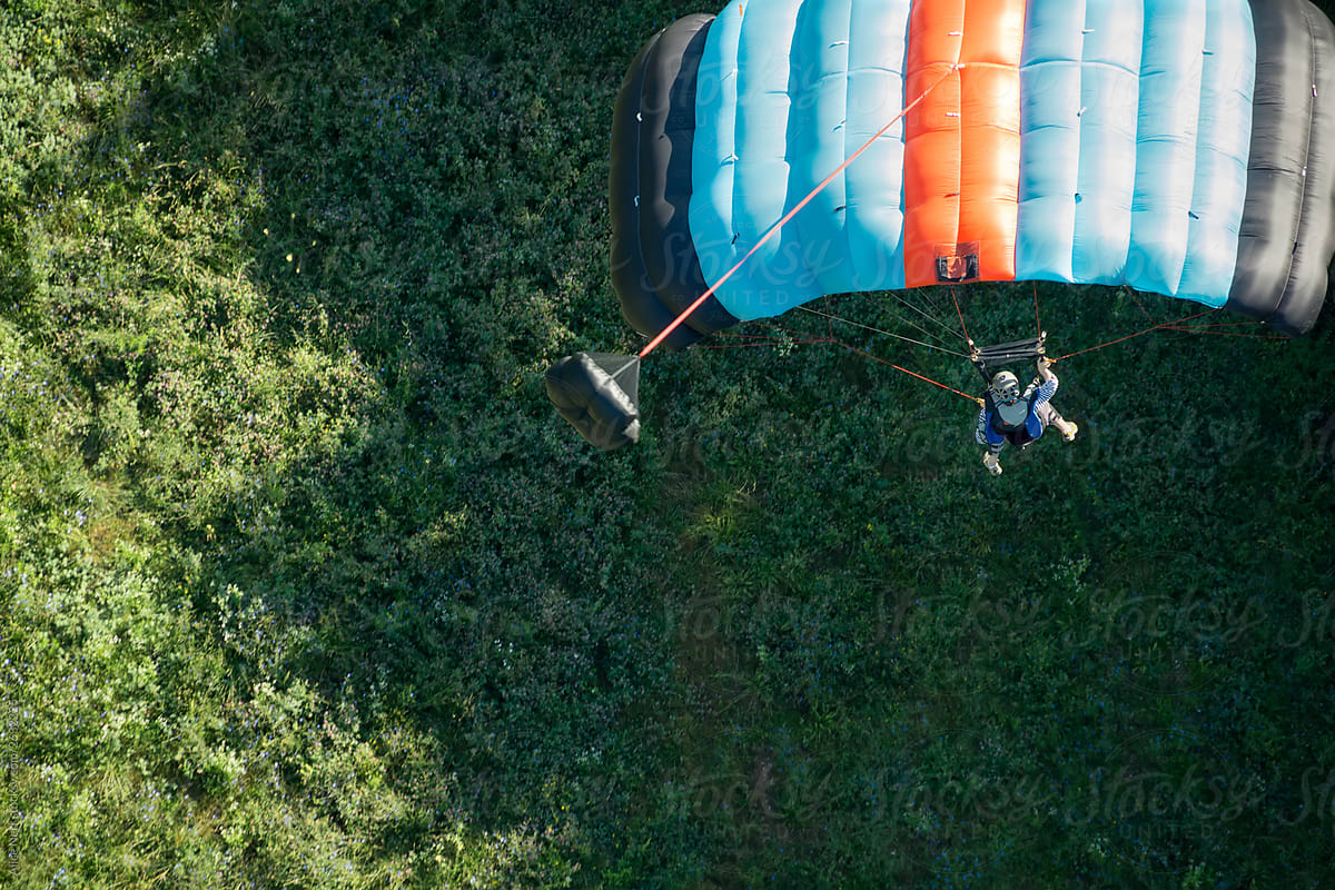 BASE jumper landing under opened parachute
