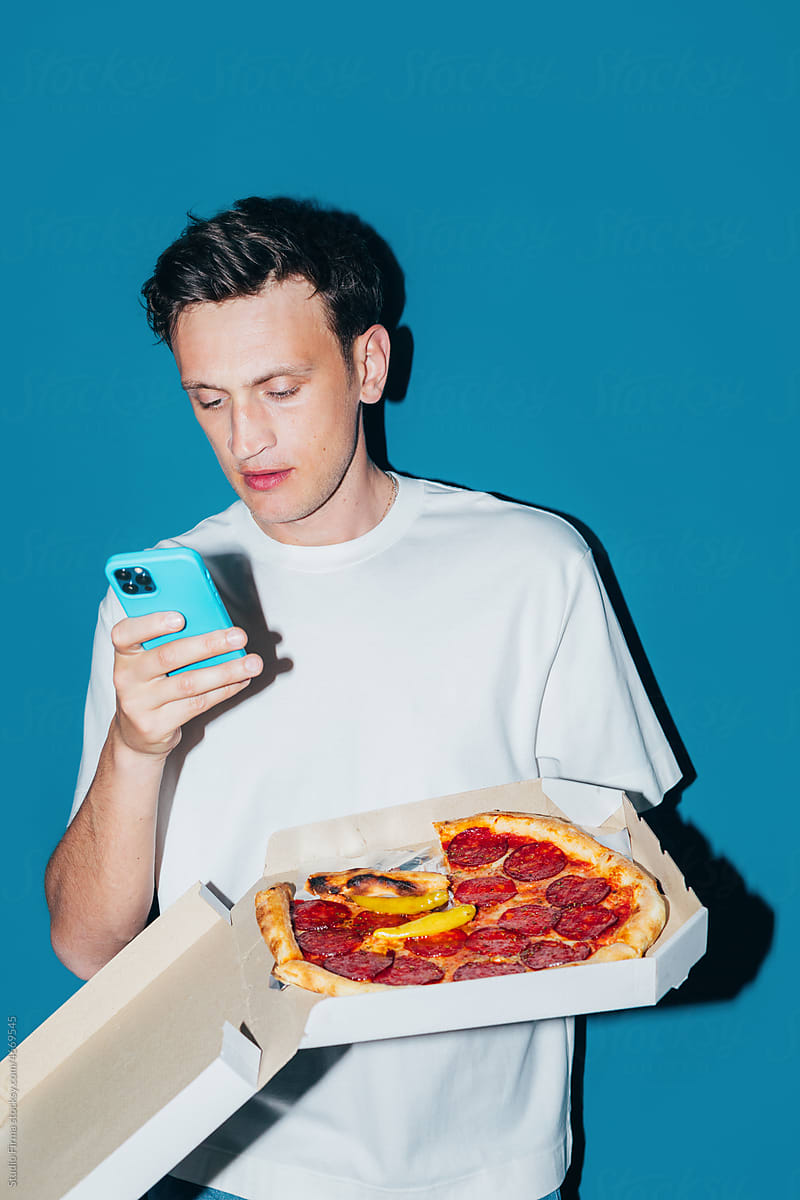 Man Holding Box with Pizza and Using Phone