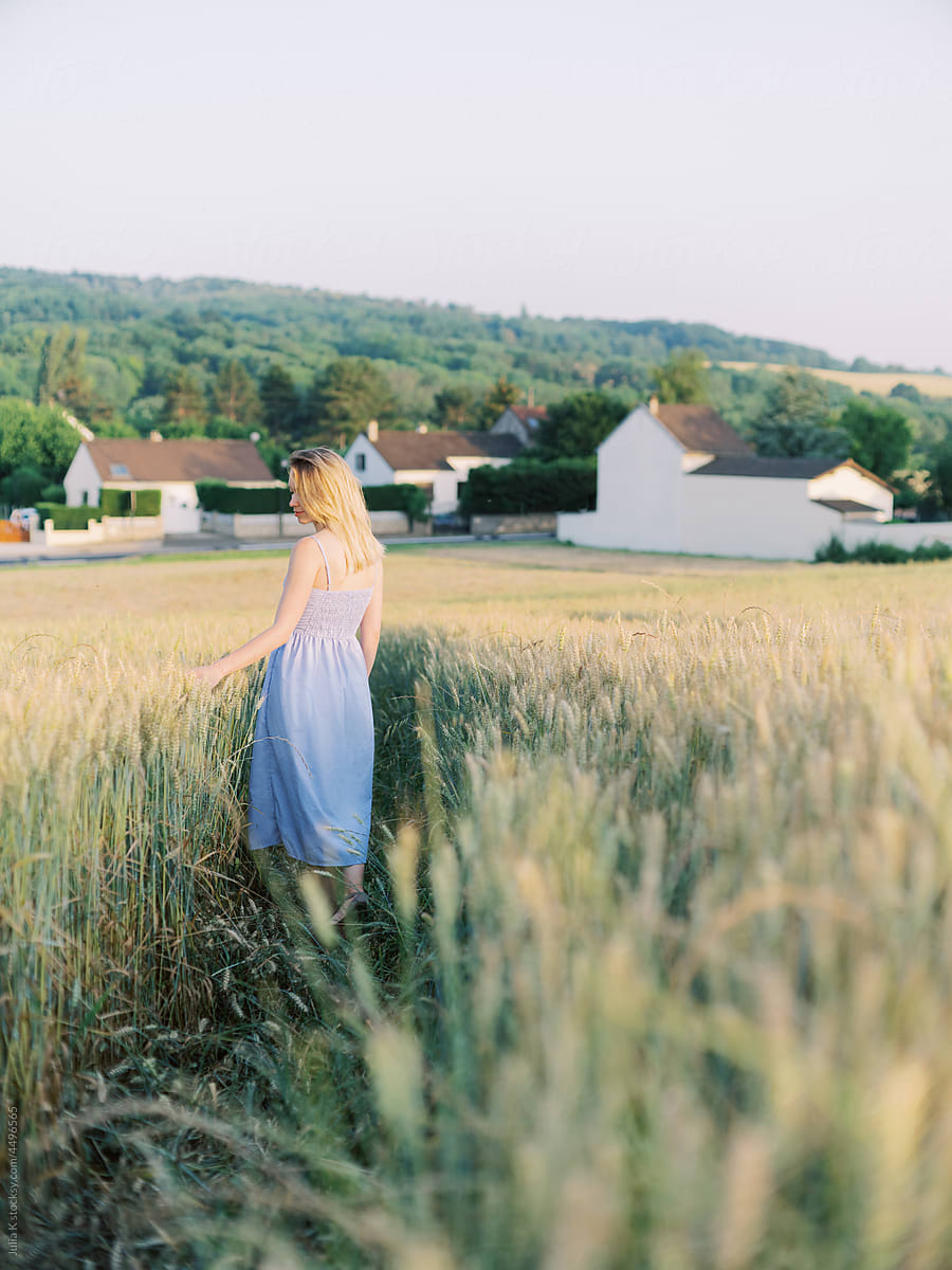 Woman Walking Across Wheat Field