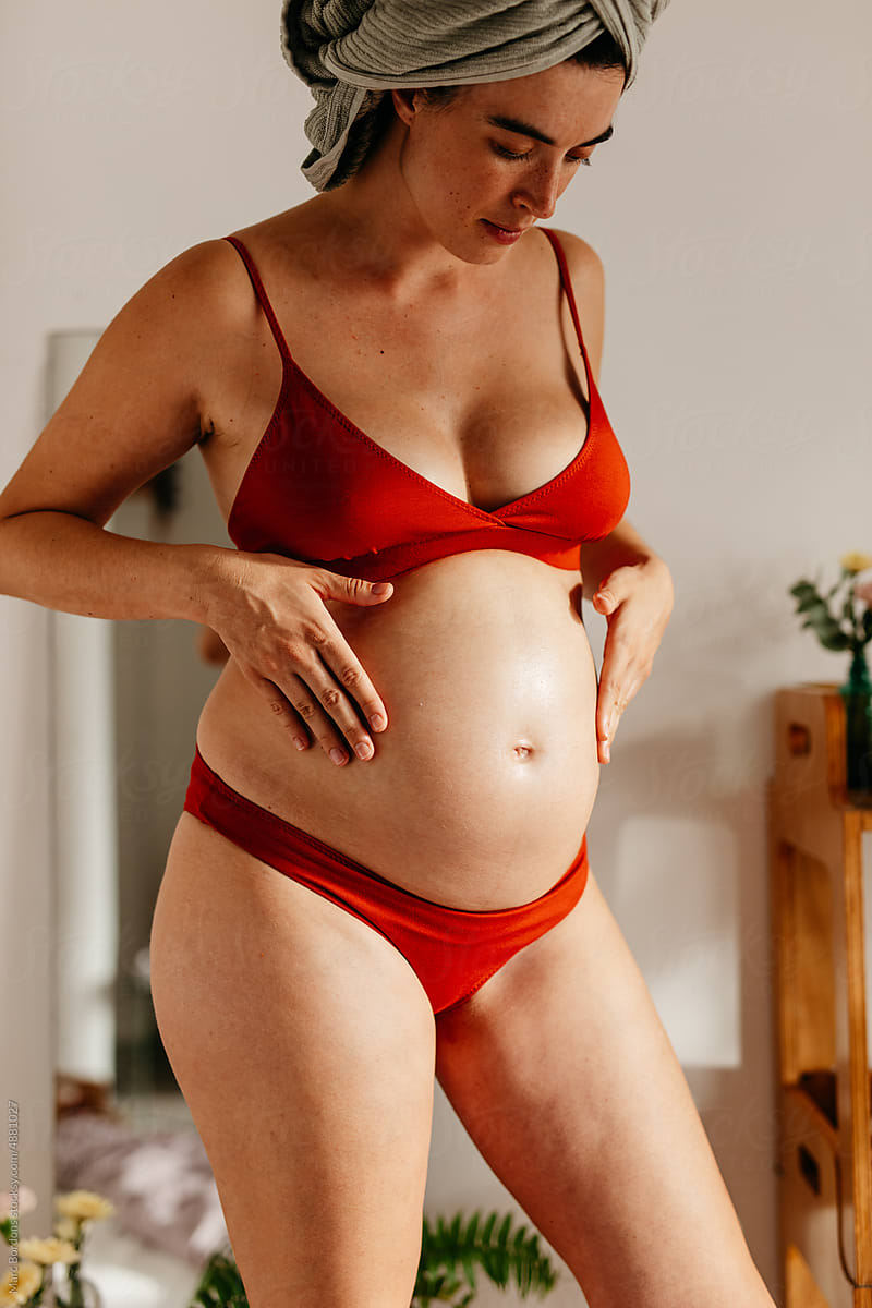 a pregnant woman massages her belly