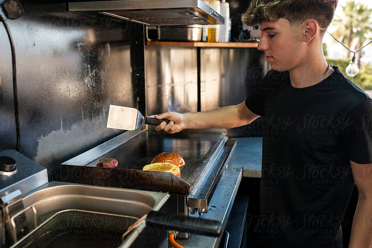 Teen chef cooking cheeseburgers in a food truck
