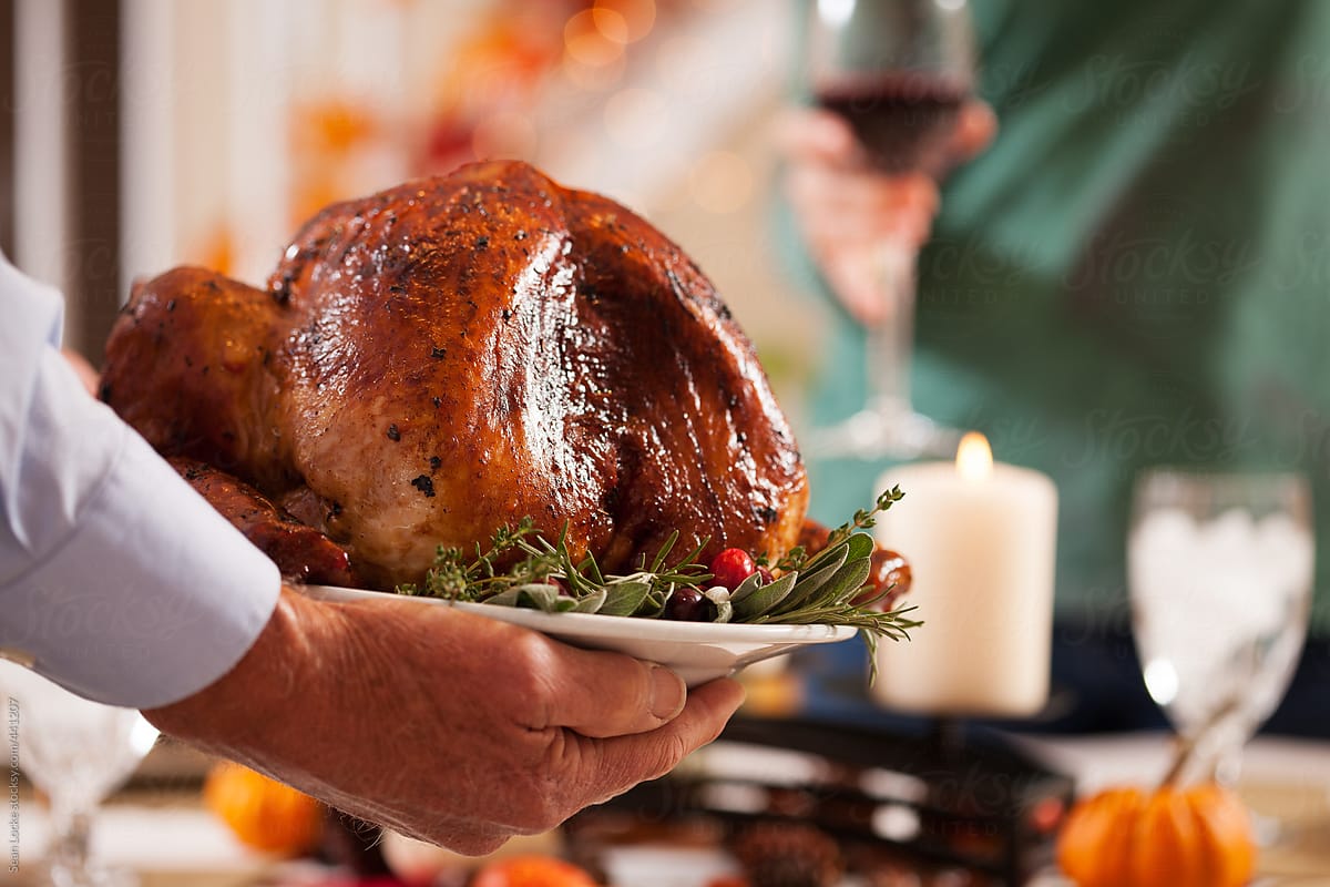 Thanksgiving: Father Carries Turkey To Table On Platter