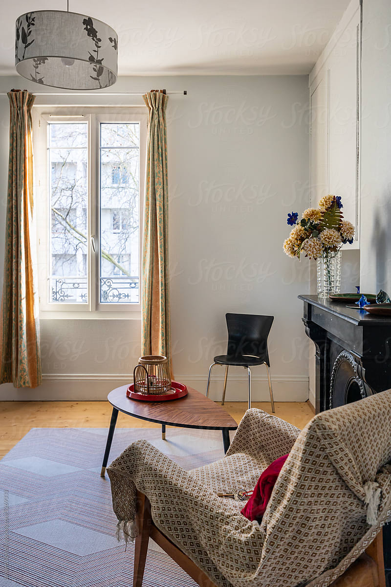 Cozy vintage french apartment with a chimney, armchair and flower vase