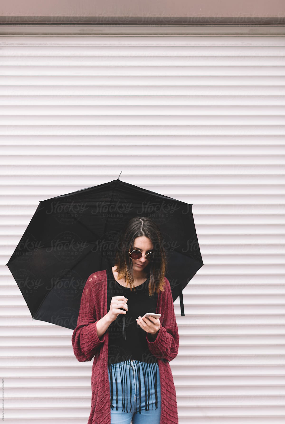 real young woman with umbrella on the phone