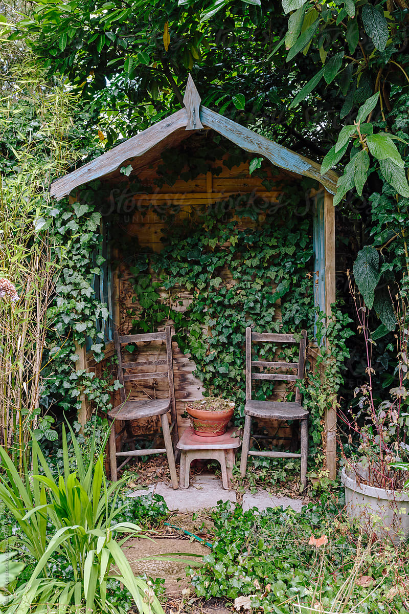 Small garden shelter with two chairs in a rural garden