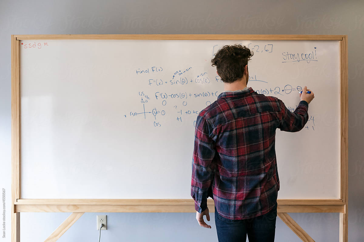 College Student Doing Math On Whiteboard