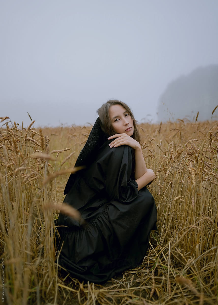 asian girl posing in wheat field in black dress