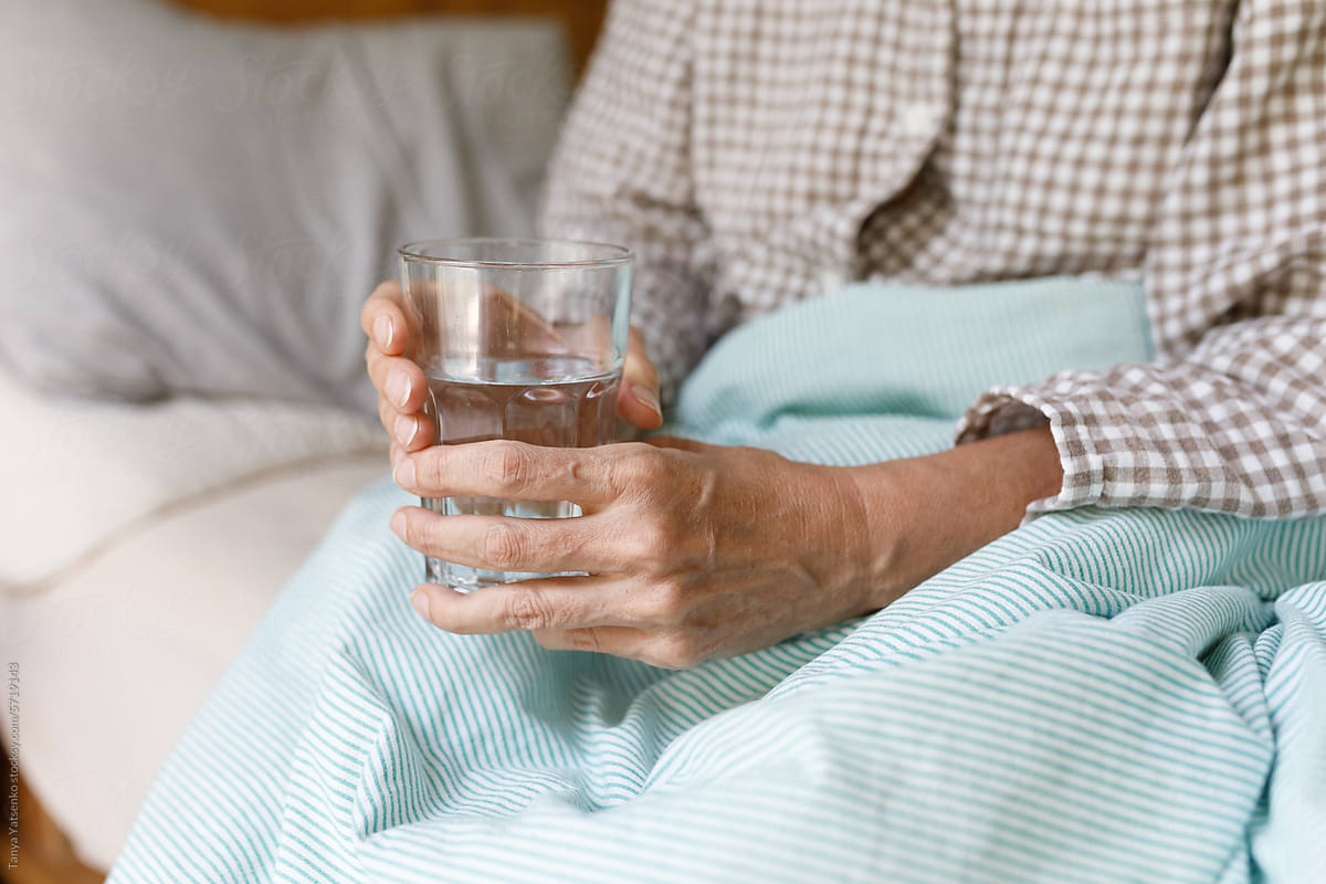 A senior woman with a glass of water