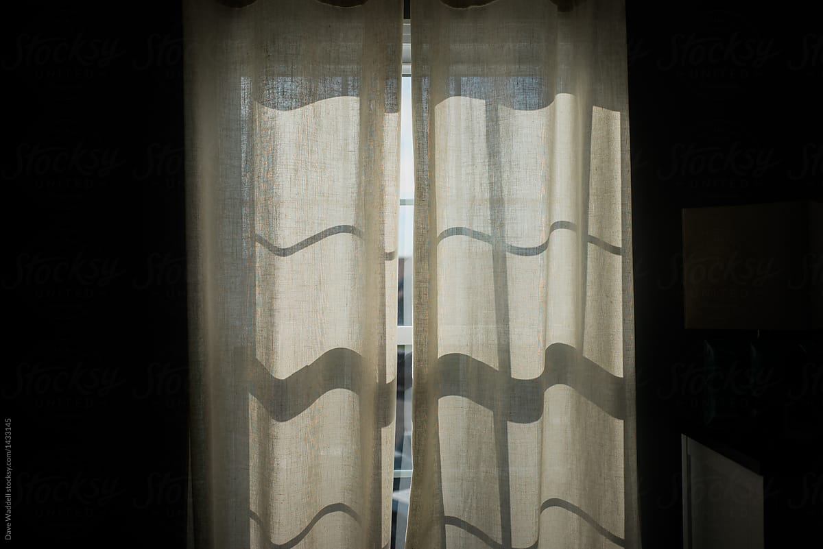 Sunlight comes through the window and illuminates the curtains