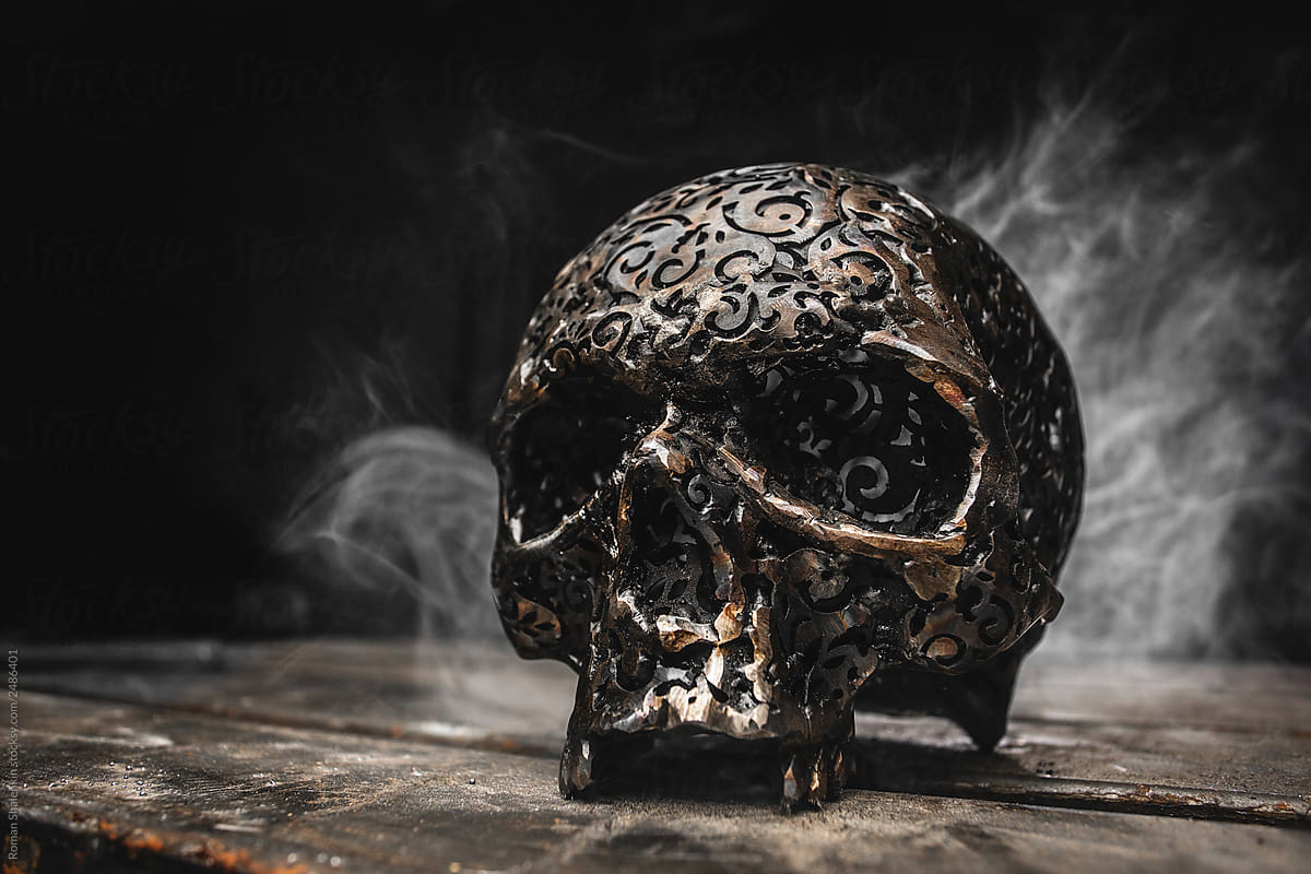 ornamental metal skull with smoke on the background