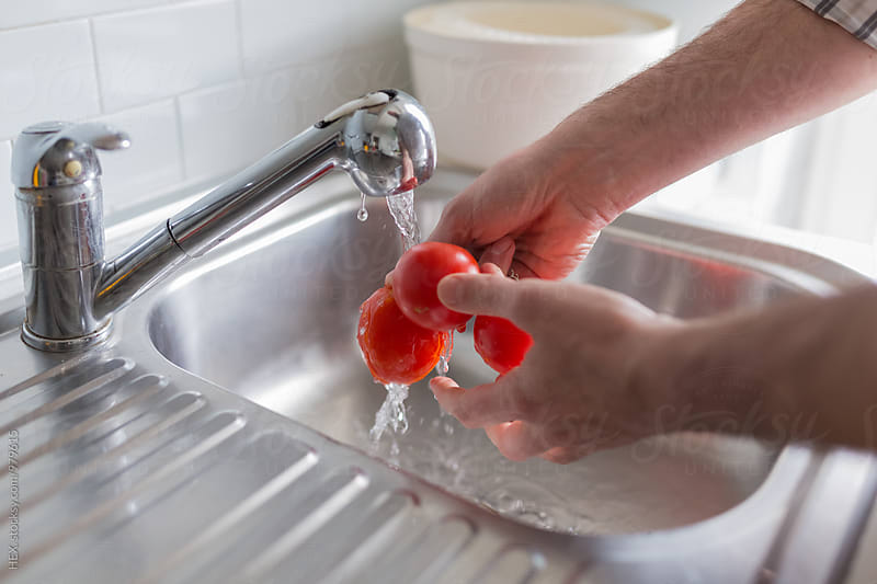 Man Washing Tomatoes under the Tap Water