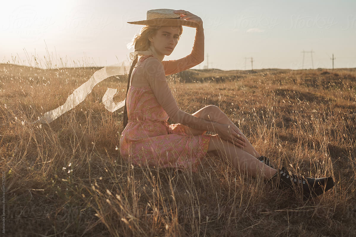 Elegant Blond Woman Wearing Pink Silk Dress And Sun Hat In The Nature