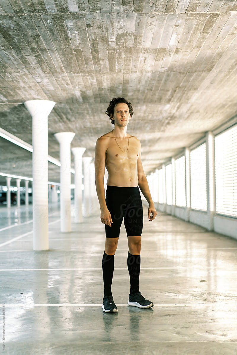 Shirtless sportsman standing in passage
