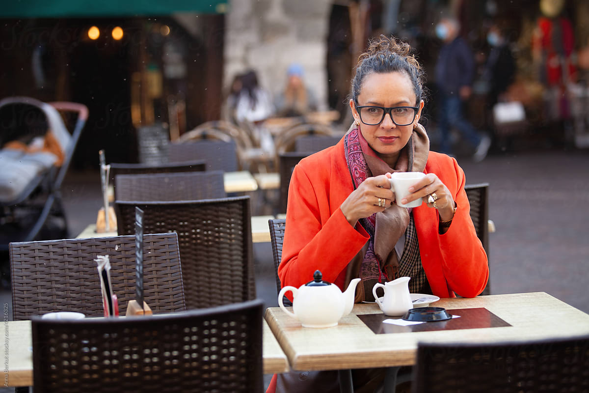 thoughtful mature woman drinking tea in cafe