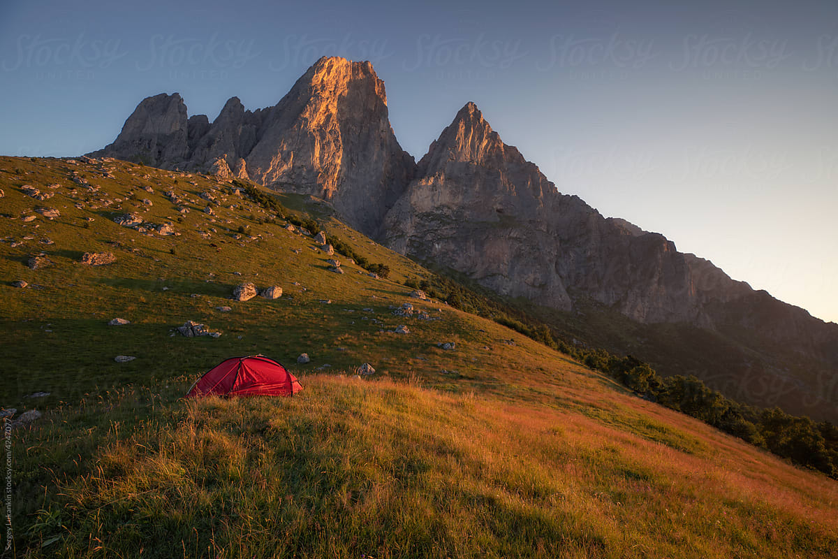 Tent at sunrise on the background of mountains