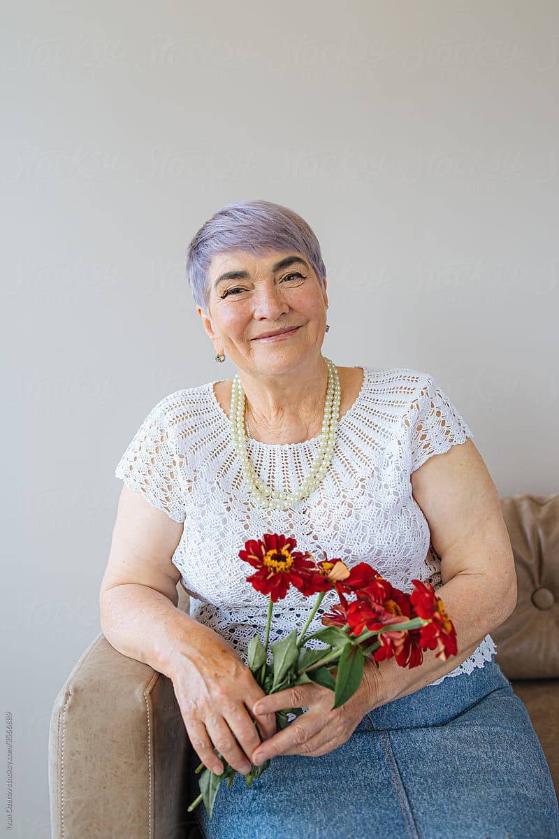 smiling elderly woman holding a bouquet of flowers