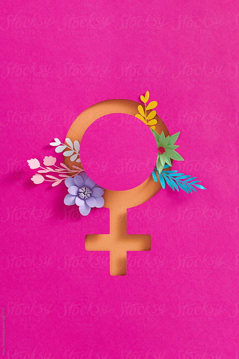 Female gender symbol lying with paper cut flower on color