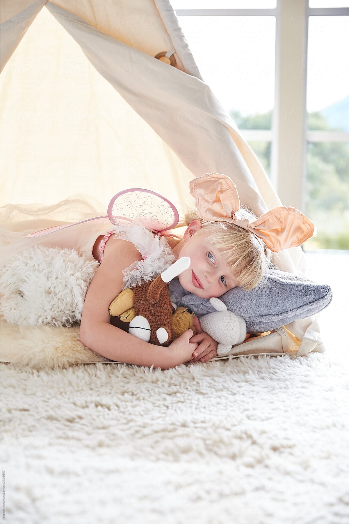 Adorable little girl hugging her stuffed animals