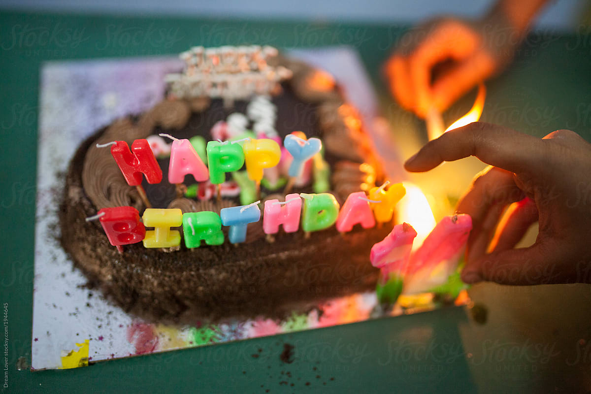 A girl illuminating candle in a Happy Birthday celebration