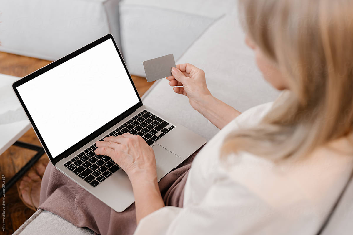 Woman using laptop and plastic card during online shopping at home