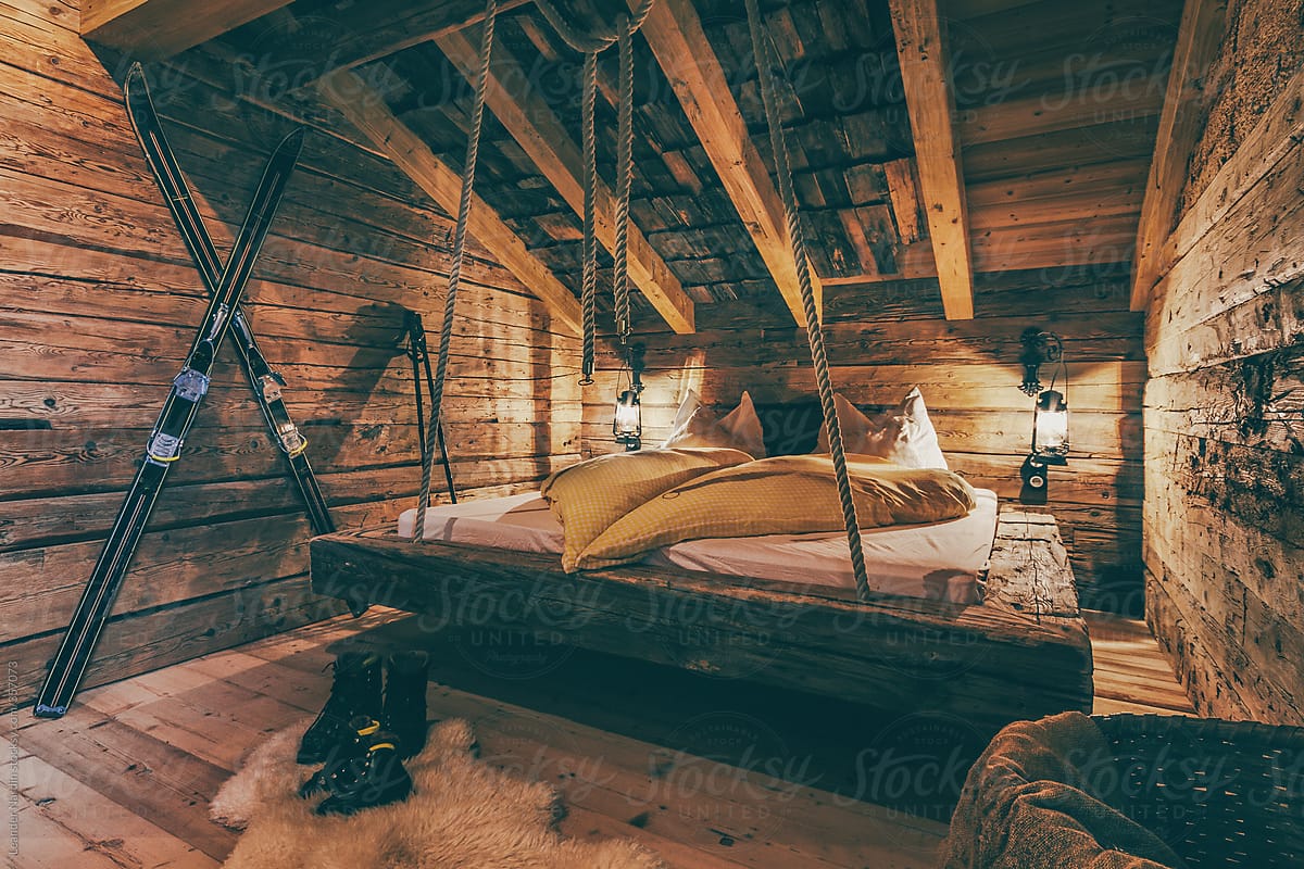 rustic bedroom with ski in old wooden alpine cabin