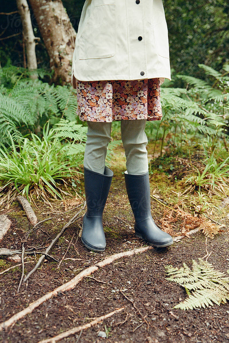 Girl\'s feet in rain shoes in the forest